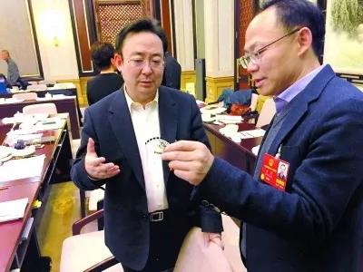 昨天,北京團(tuán)小組會休息的間隙,程京代表(右)向夏林茂代表介紹基因芯片。張宇攝